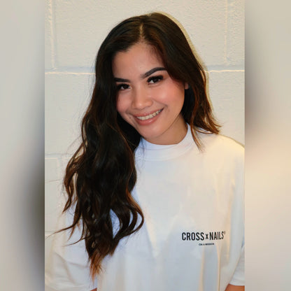 Crossxnails® Oversize Tee in Lucent White, worn by a model showcasing the back logo design against a neutral background.